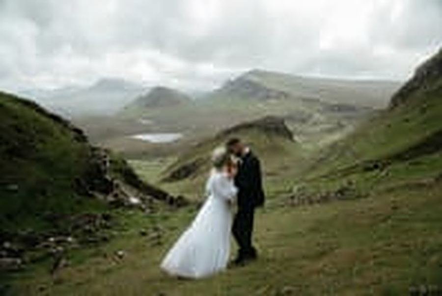 A couple embracing in wedding attire in green highlands