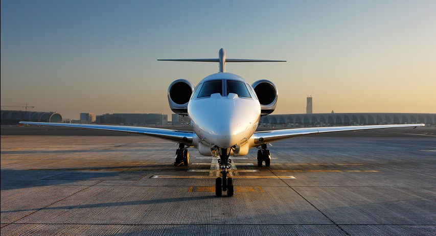A private jet waiting on the tarmac at sunrise